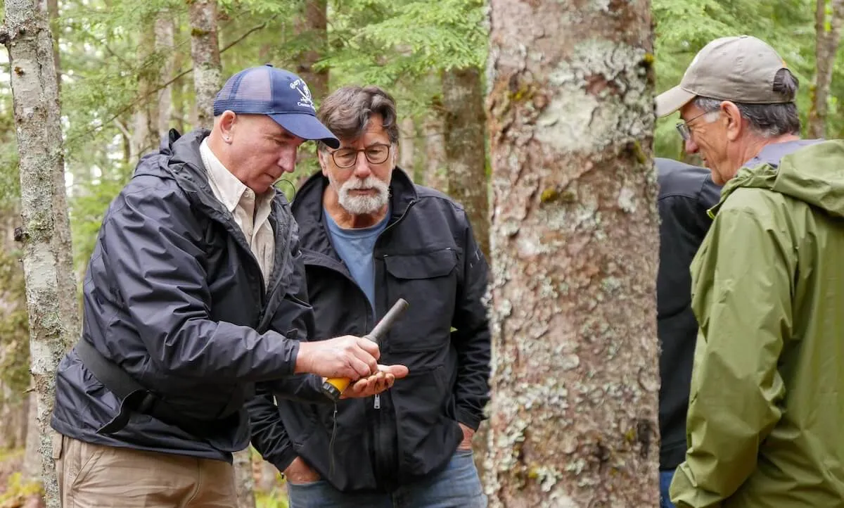 Two men looking at a tree in 'The Curse of Oak Island'