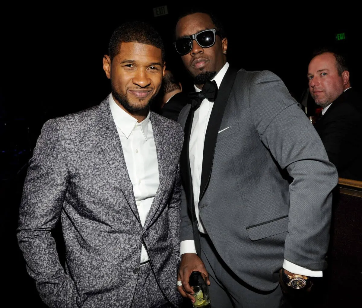 Usher and Diddy wear gray suits and stand together.