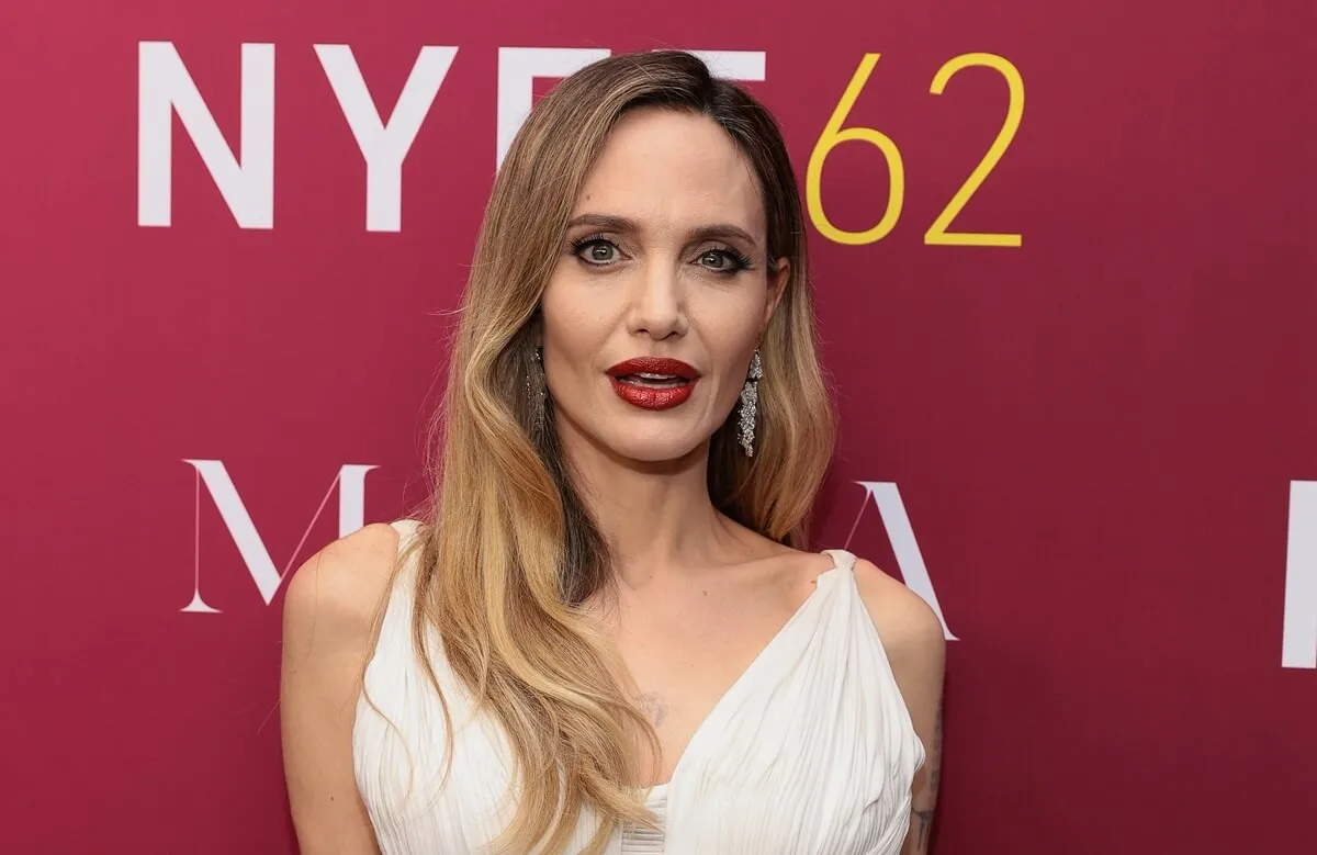 Angelina Jolie posing in a white dress at a screening for 'Maria'.