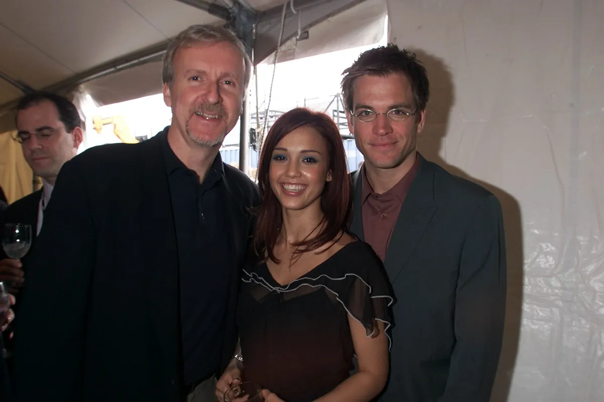 Jessica Alba posing alongside Michael Weatherly and James Cameron.