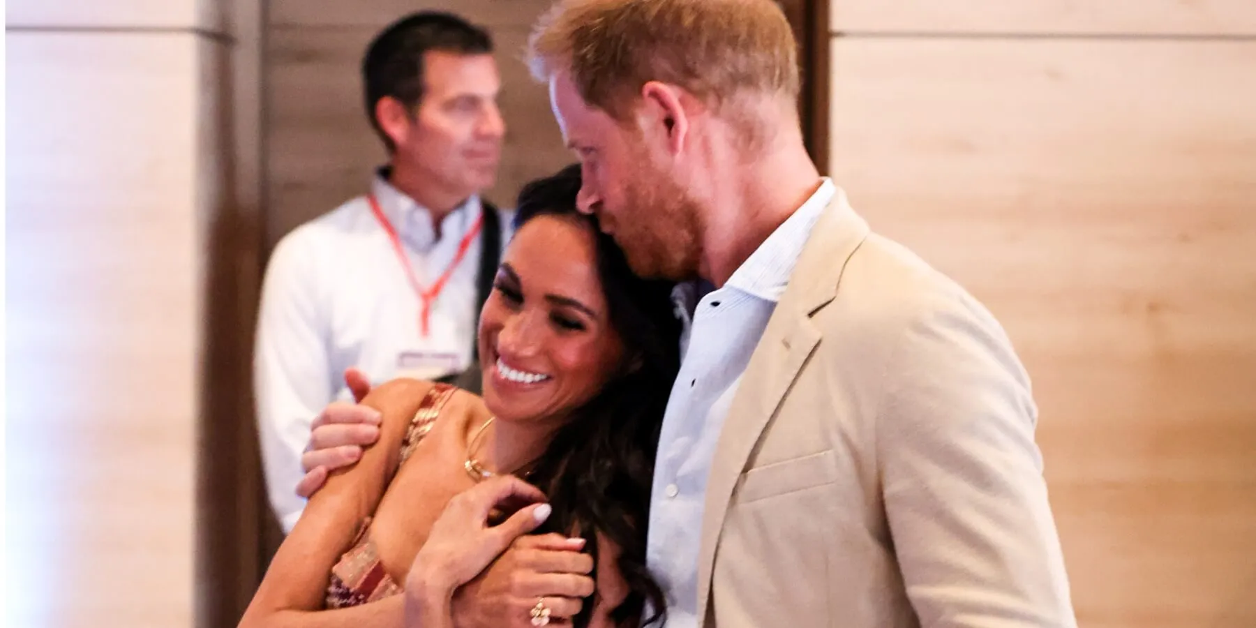 Prince Harry kisses Meghan Markle on her head in 2024.