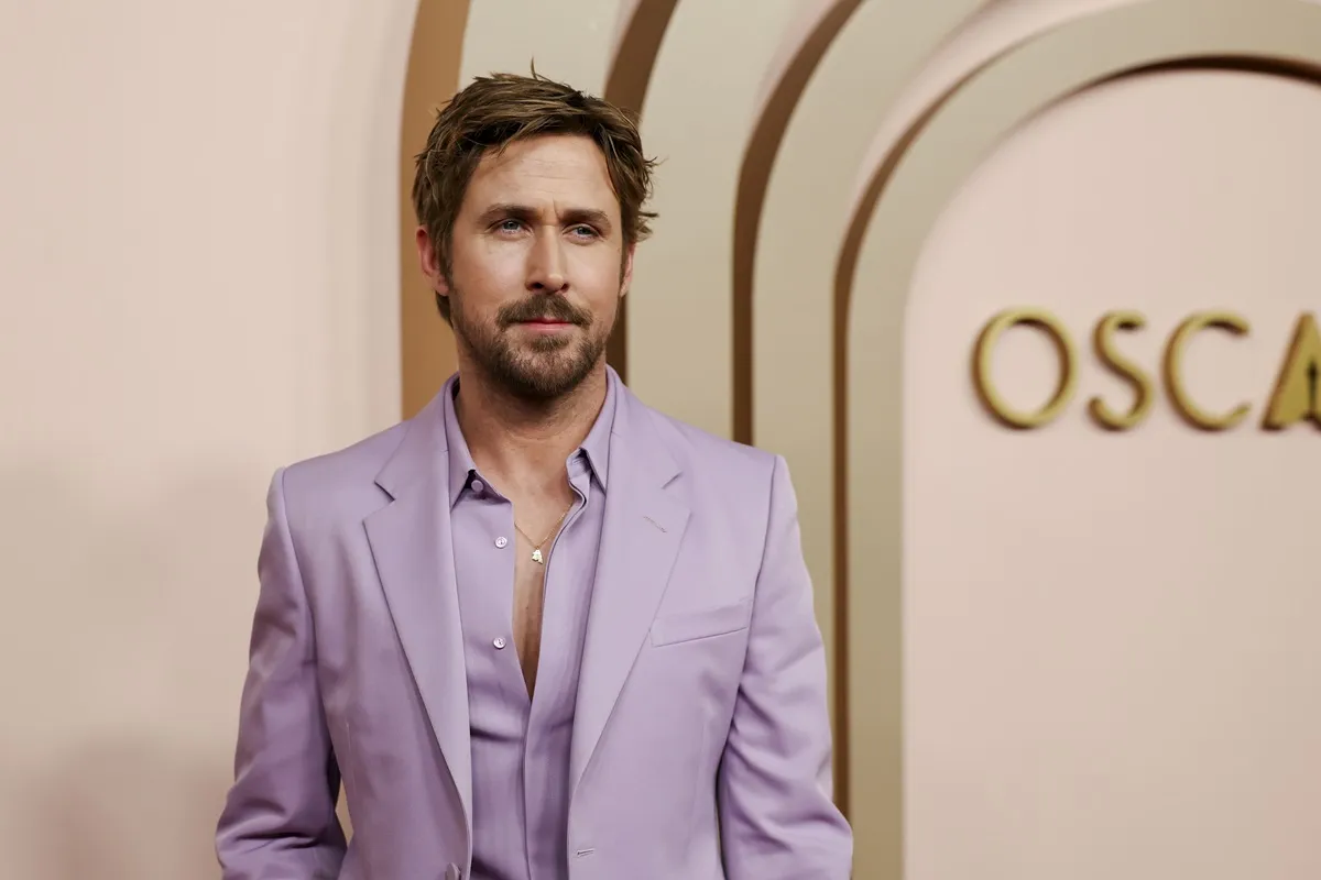 Ryan Gosling posing at the Oscars in a purple suit.