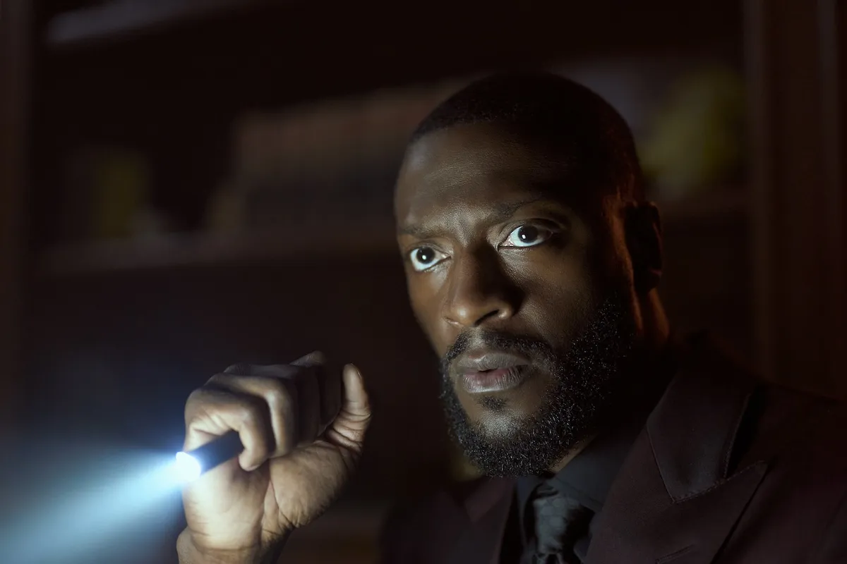 Aldis Hodge holding a flashlight and looking serious in 'Cross' on Prime Video