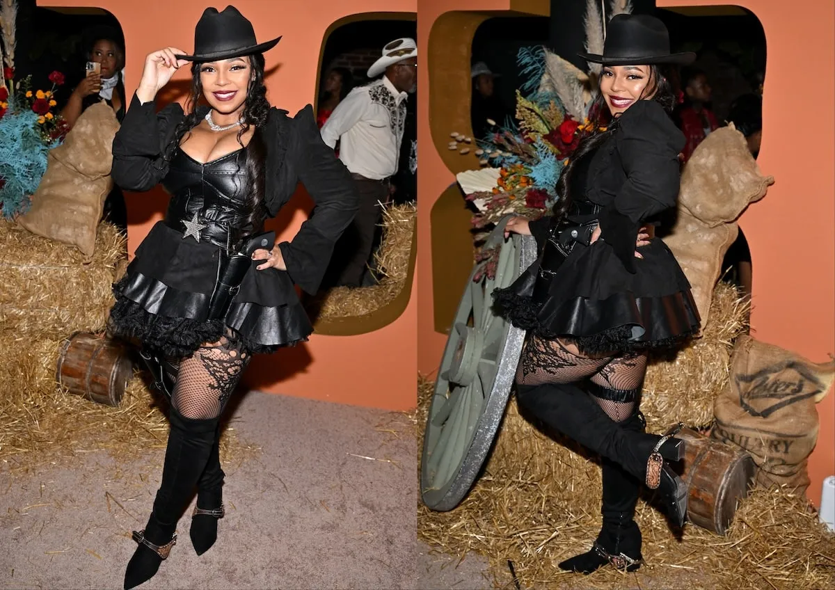 Wearing a black cowgirl costume, Ashanti smiles in front of hay bales Nelly's Halloween party and 50th birthday party