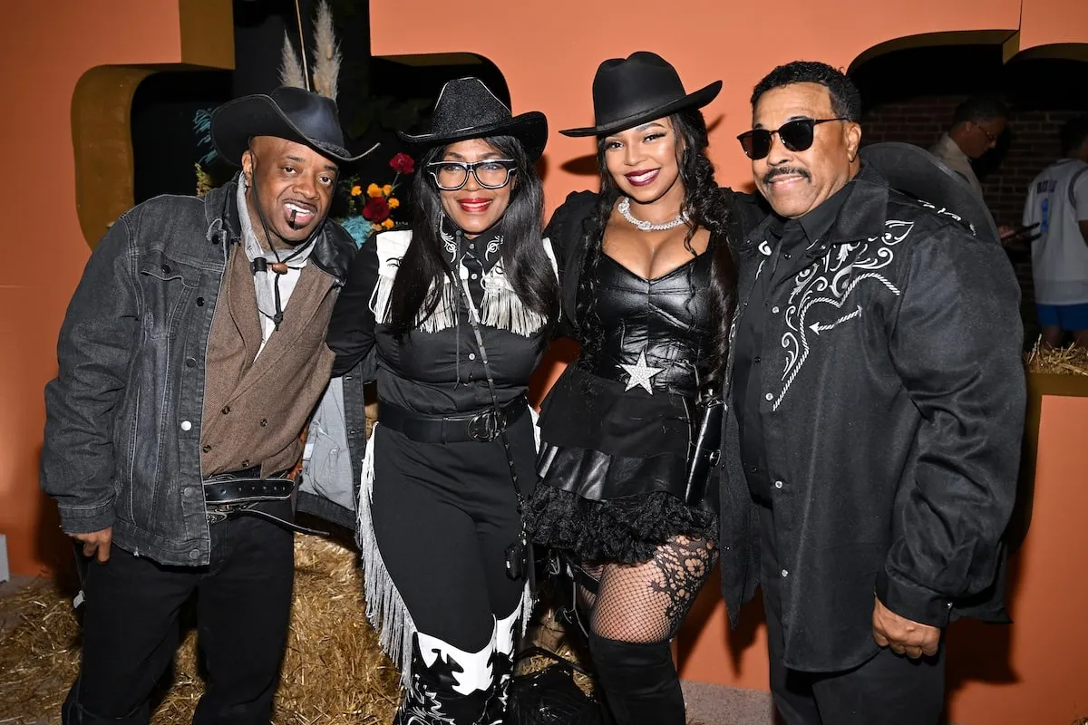 Wearing black cowboy costumes, Jermaine Dupri, Tina Douglas, Ashanti, and Ken-Kaide Thomas Douglas smile for a photo at Nelly's Halloween party