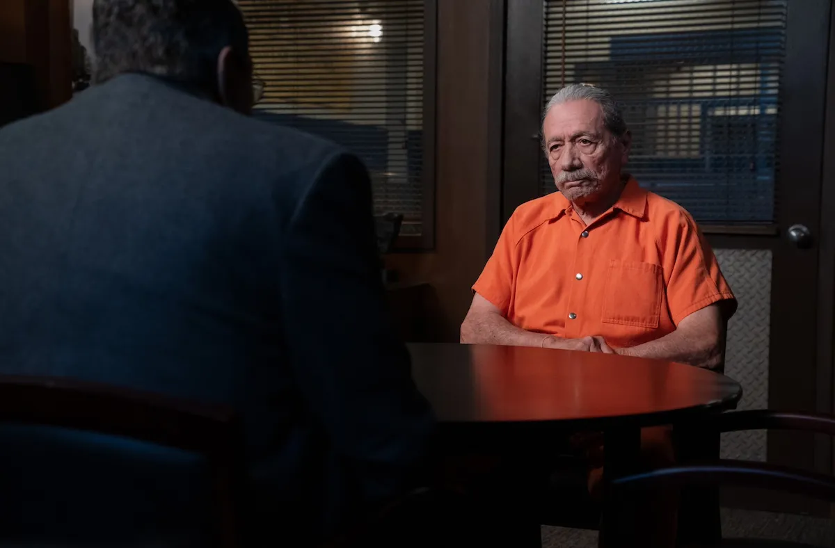 Edward James Olmos, in an orange prison jumpsuit, sits at a table talking to Tom Selleck, whose back is to the camera, in the 'Blue Bloods' series finale