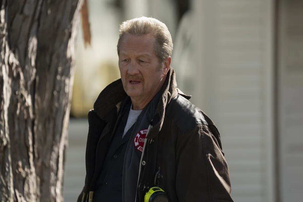 Mouch wearing a CFD jacket and standing outside in 'Chicago Fire'