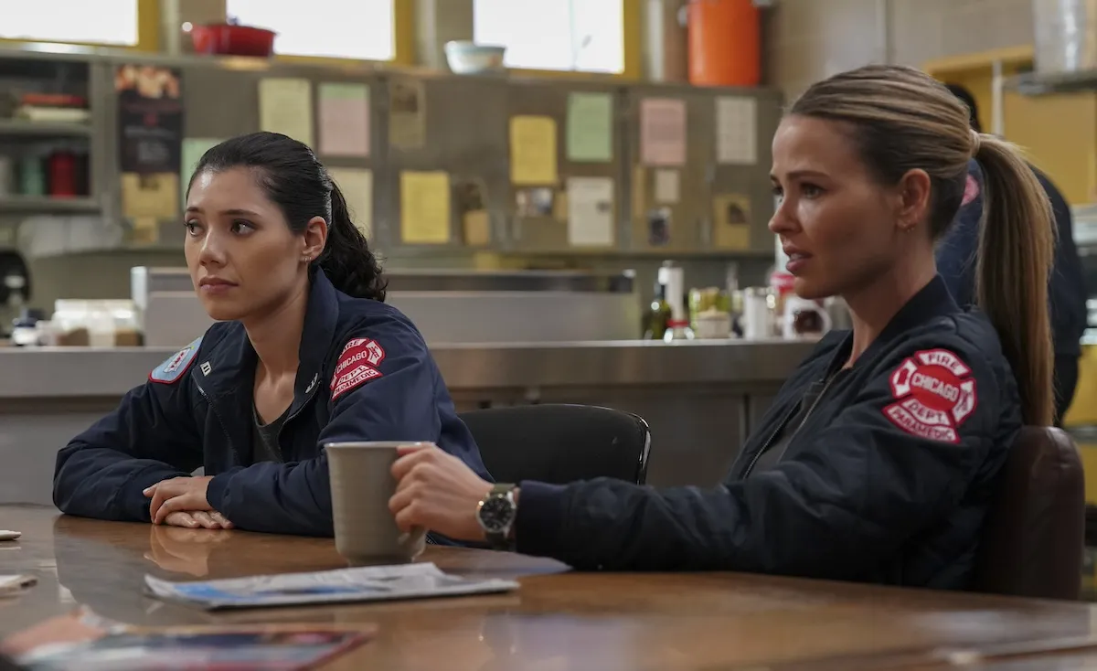 Violet and Novak sitting at a table with coffee cups in 'Chicago Fire' Season 13