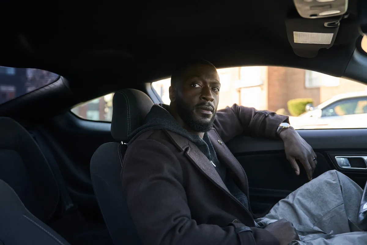 Aldis Hodge sitting in a car in Prime Video's 'Cross'