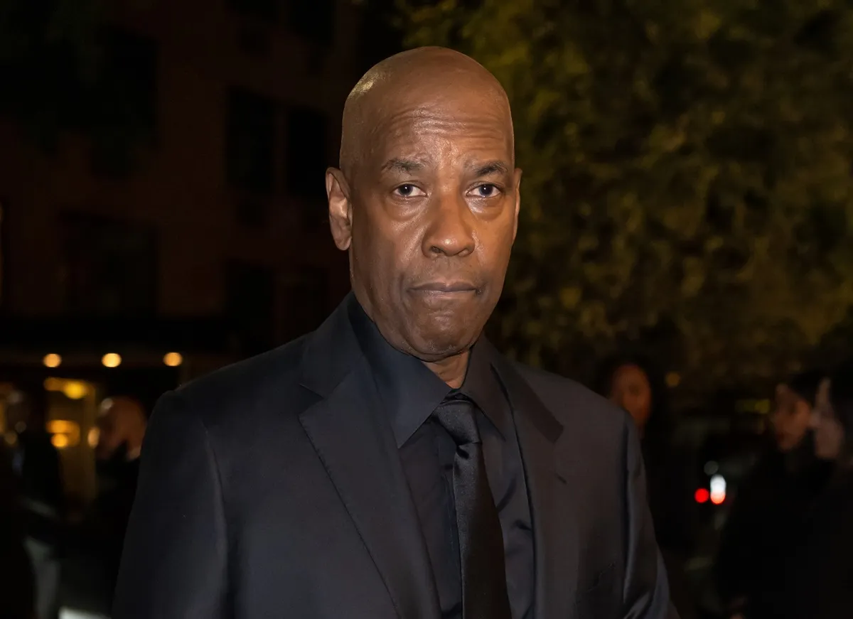 Denzel Washington posing in a black suit at The Museum of Modern Art Film Benefit.