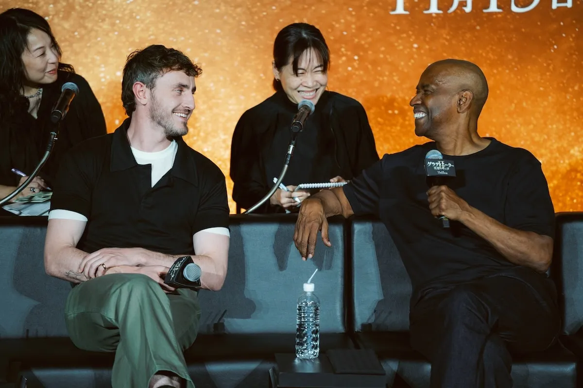 Paul Mescal and Denzel Washington laugh with a reporter during their Gladiator II press tour