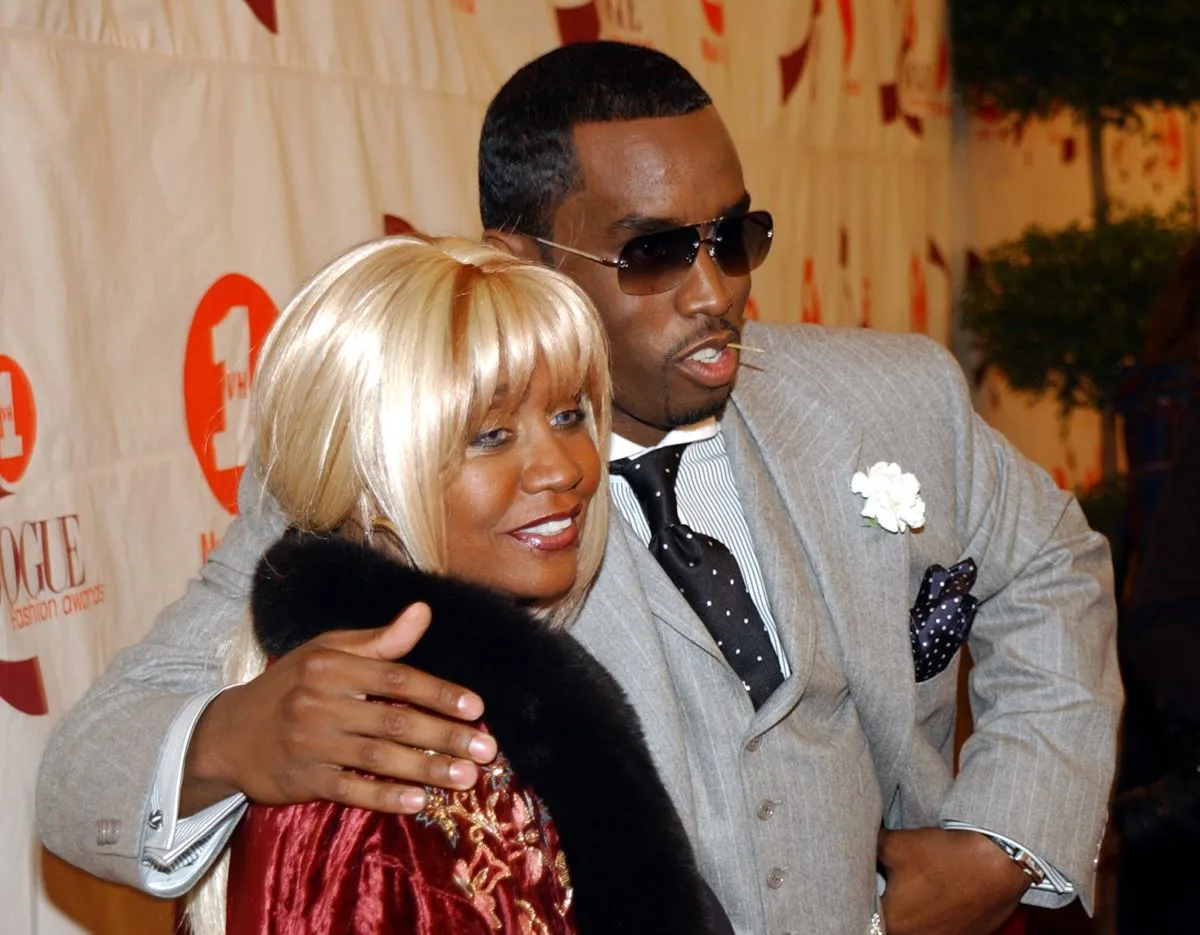 Sean 'Diddy' Combs wears a gray suit and stands with his arm around his mother Janice's shoulders.