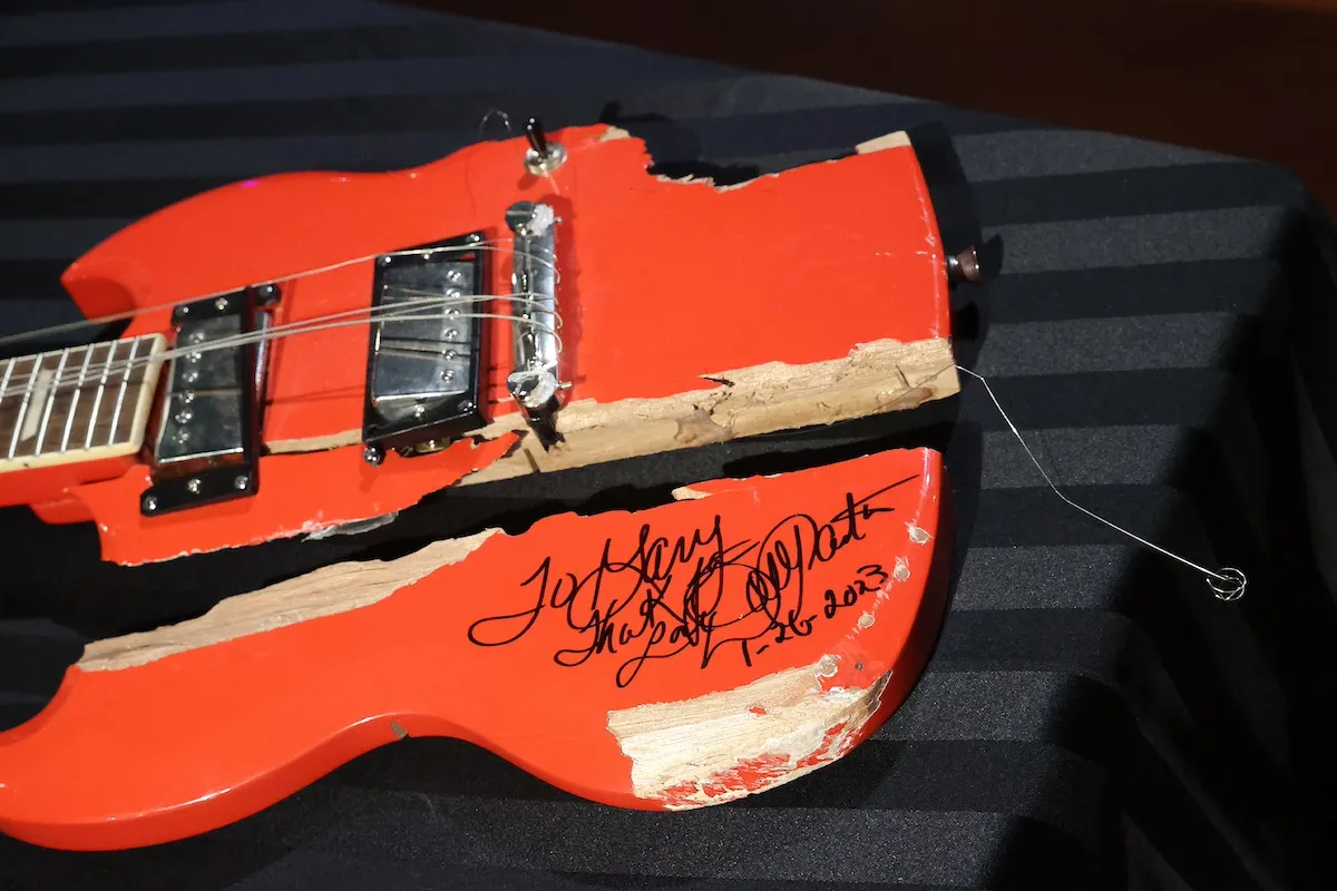 Broken red guitar signed by Dolly Parton