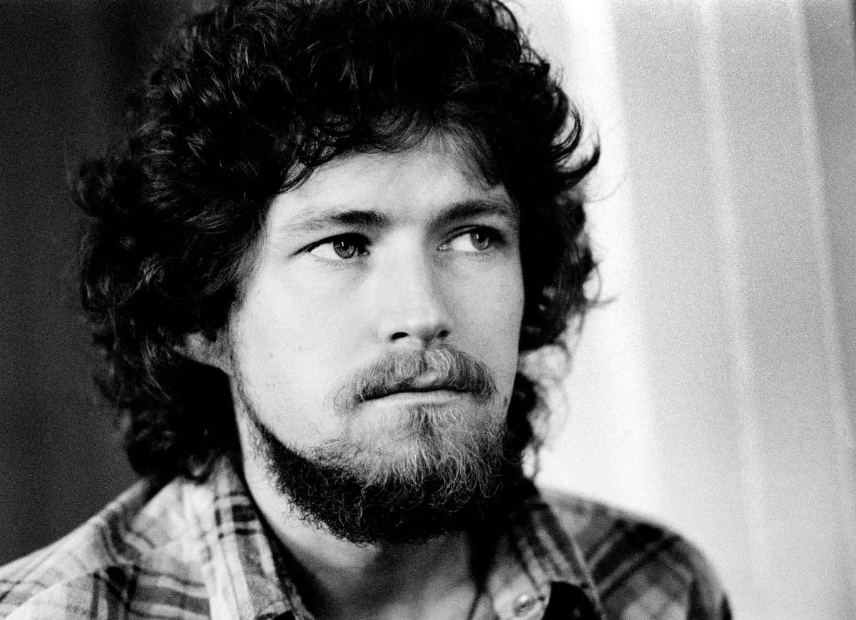 A black and white picture of Don Henley wearing a plaid shirt.