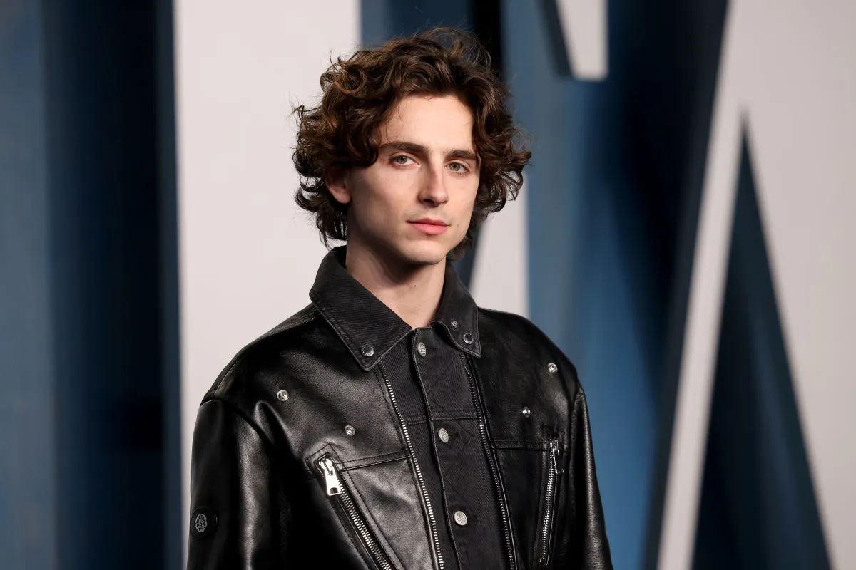 Timothée Chalamet wears a black leather jacket.