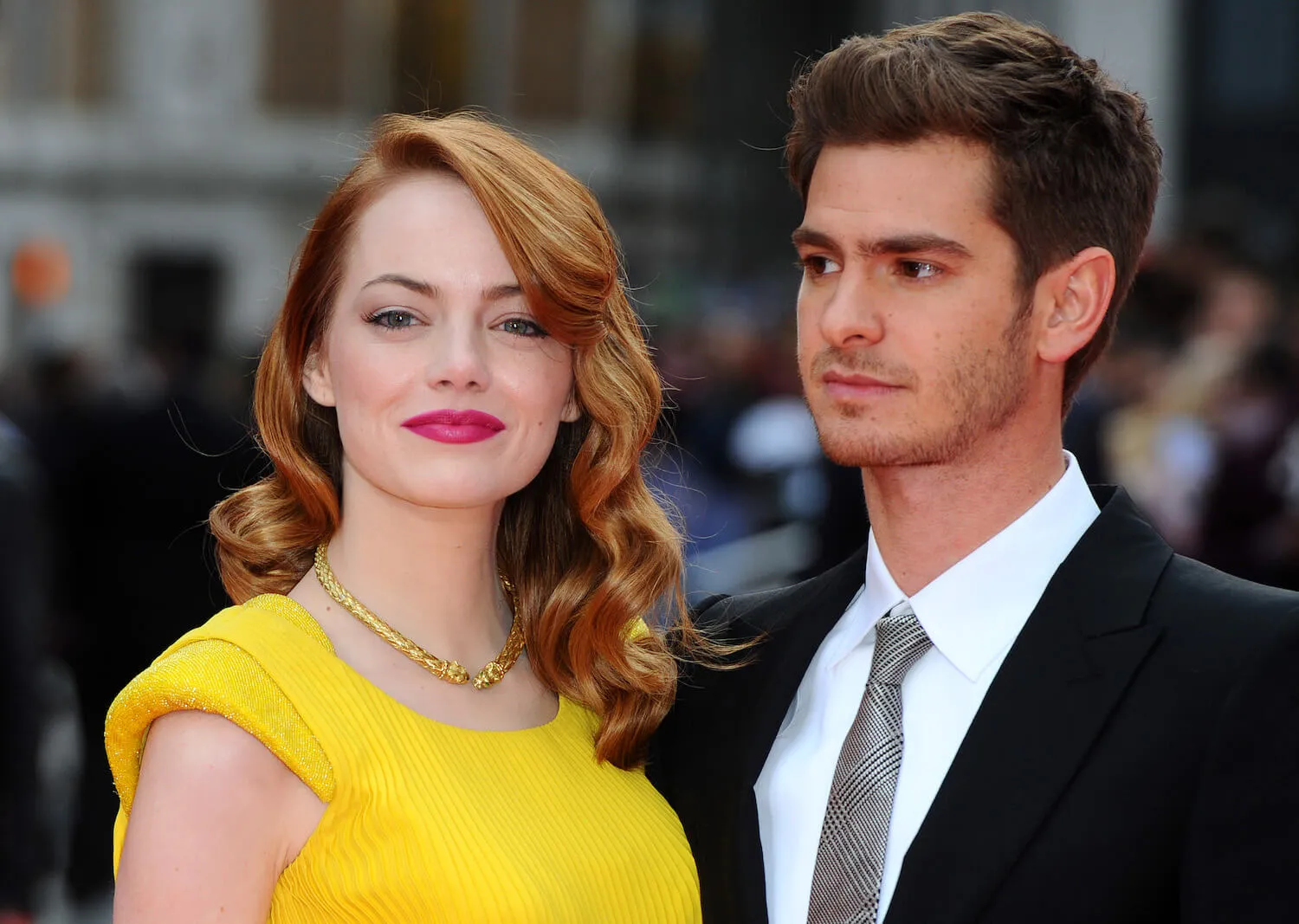 Emma Stone wearing a yellow dress standing next to Andrew Garfield in a suit at 'The Amazing Spider-Man 2' premiere