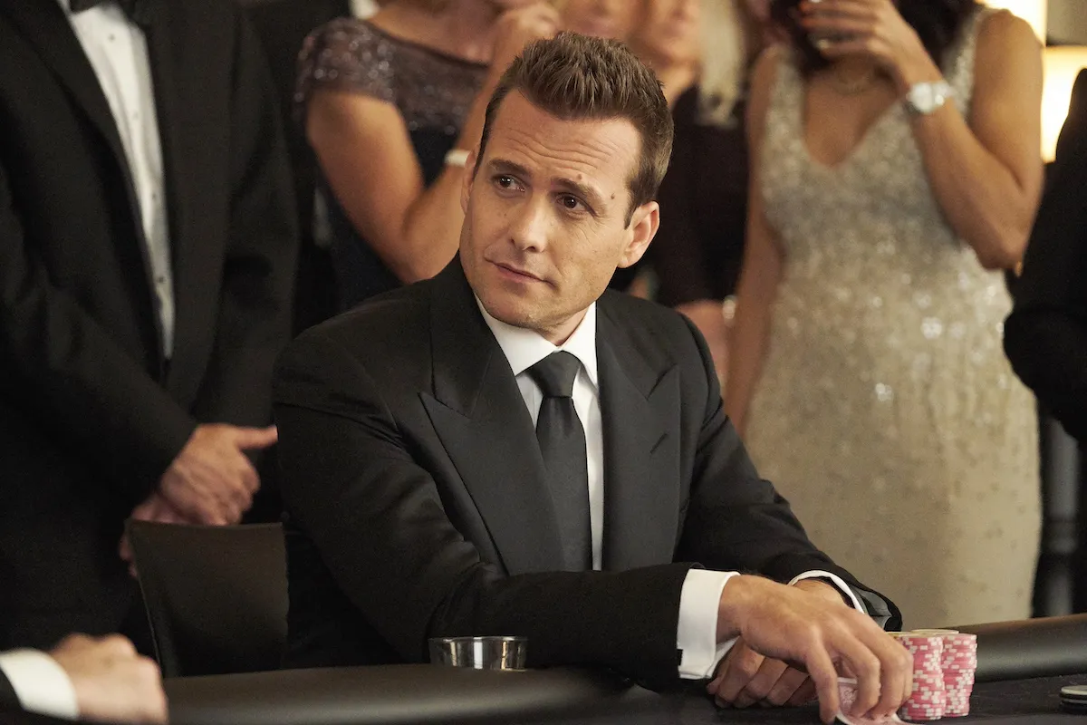 Gabriel Macht wearing a suit and playing cards in 'Suits' 