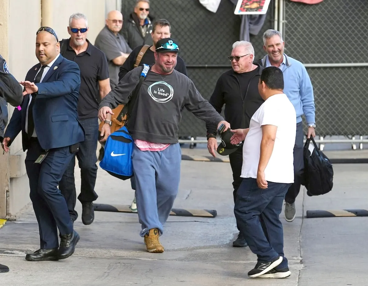 Wearing a gray sweatshirt and blue sweatpants, Garth Brooks greets fans outside of Jimmy Kimmel Live studios