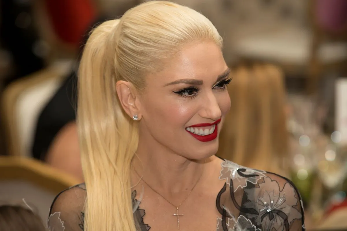 Gwen Stefani wears a black dress and has her hair in a ponytail.