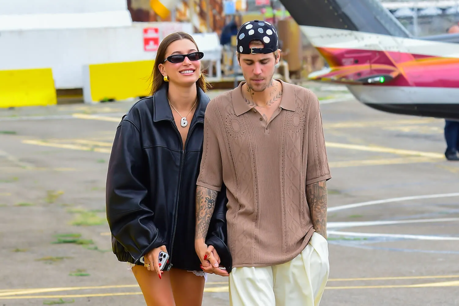 Hailey Bieber smiling while holding Justin Bieber's hand in New York City in 2023