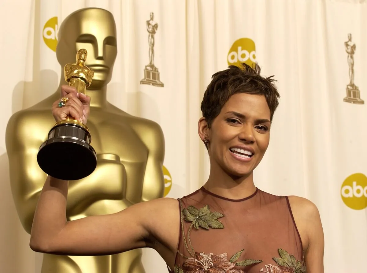 Halle Berry holding up an Oscars trophy at the Academy Awards.