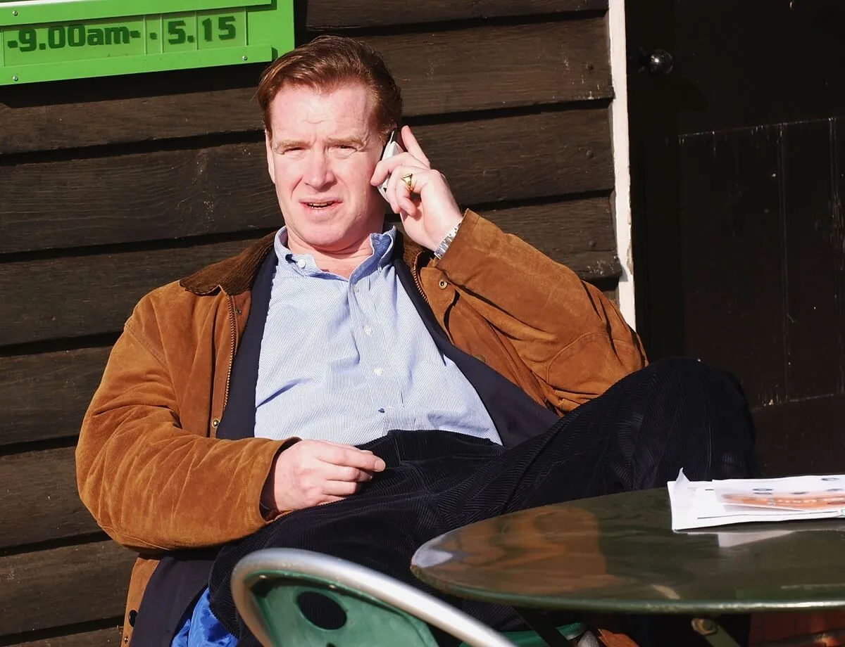 James Hewitt speaks on his phone while sitting on a bench in London's Hyde Park