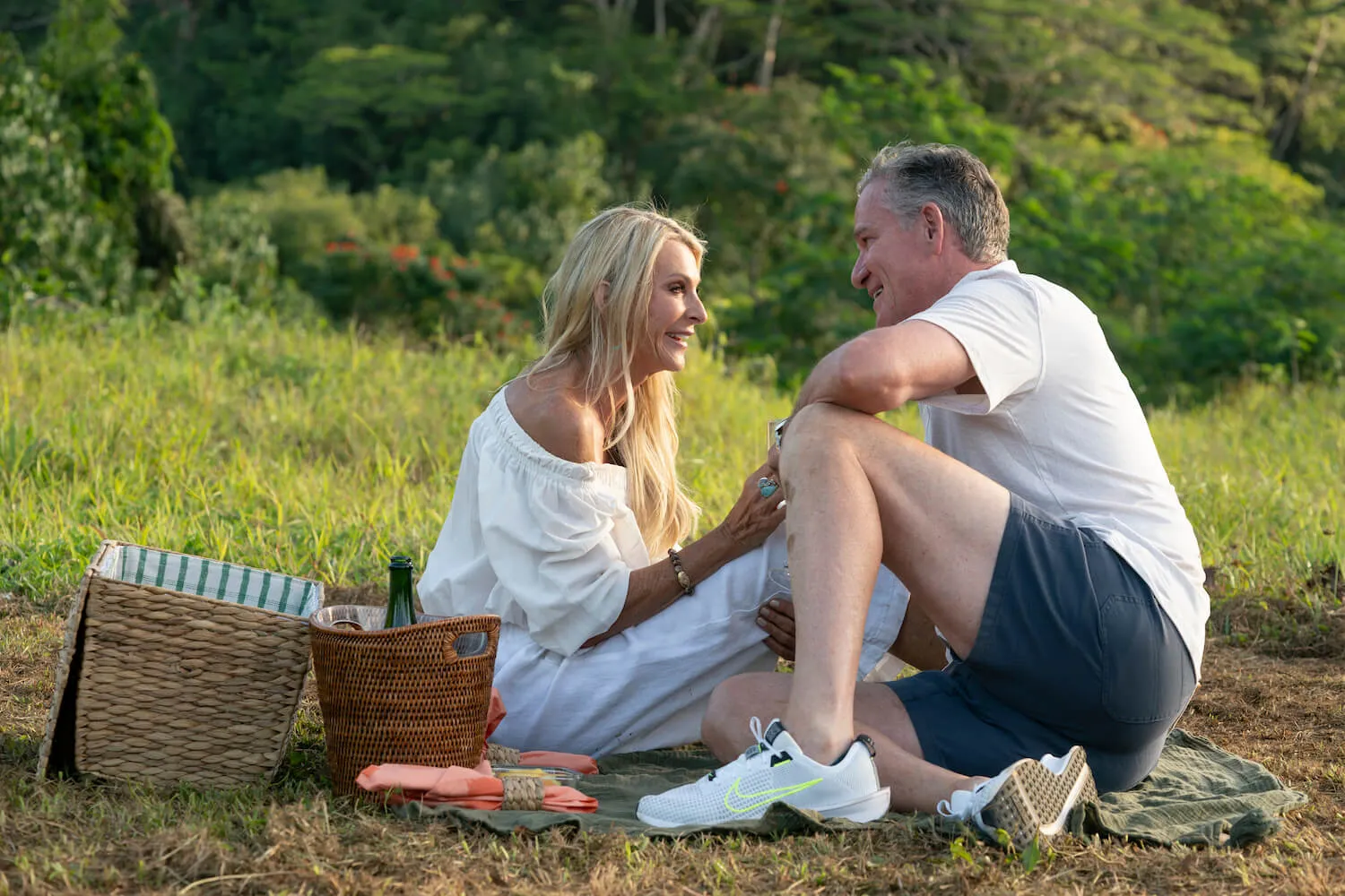 Joan Vassos and Chock Chapple sitting next to each other in a field with a picnic in 'The Golden Bachelorette'