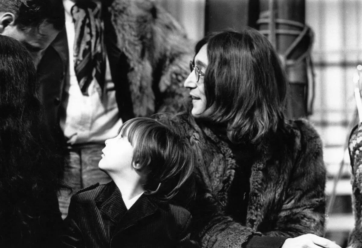 A black and white picture of Julian Lennon and John Lennon looking up and sideways.