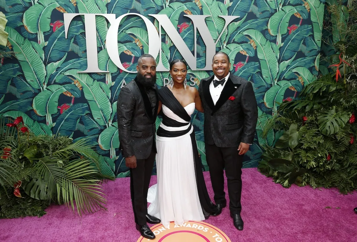 Tony nominated producer Kandi Burress stands with her husband and producing partner in front of the Tony Awards sign