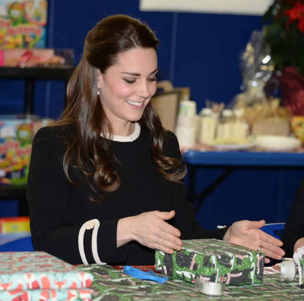 Kate Middleton takes part in gift wrapping with volunteers as she visits Northside Center for Child Development