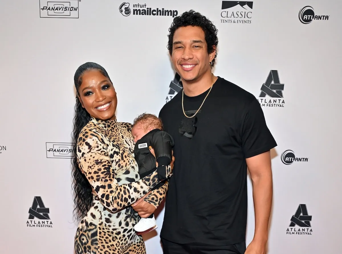 Wearing a leopard print bodysuit, Keke Palmer poses with her husband and newborn son on the red carpet