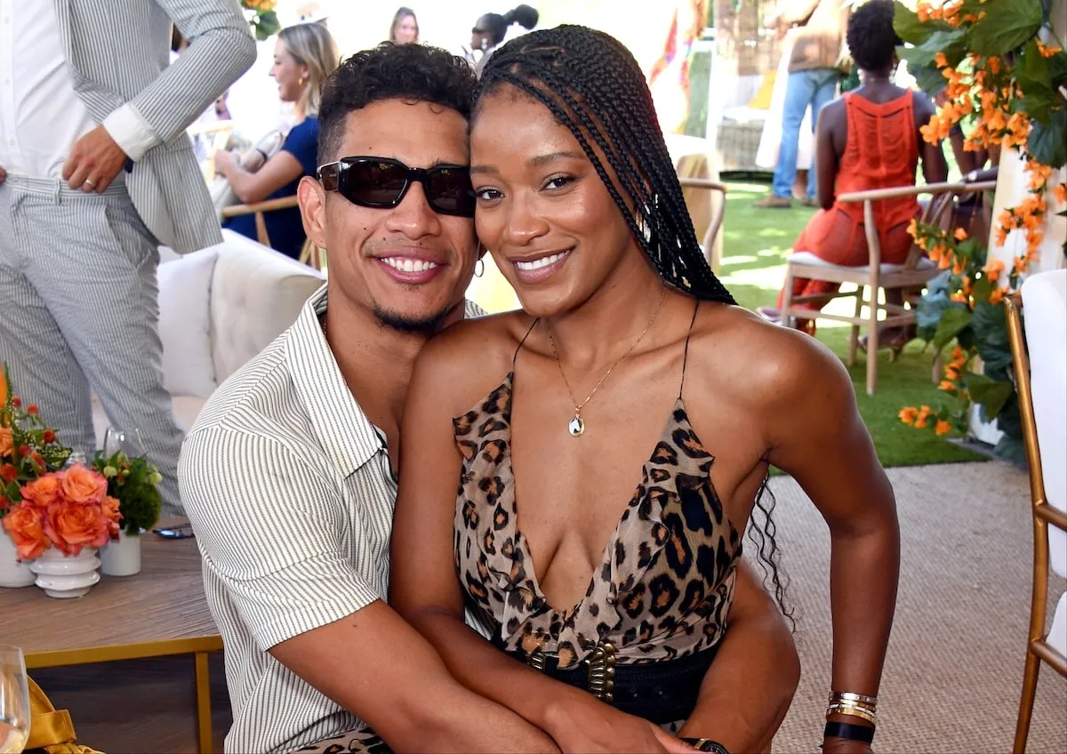 Wearing a leopard print dress, Keke Palmer sits in her then-boyfriend's lap