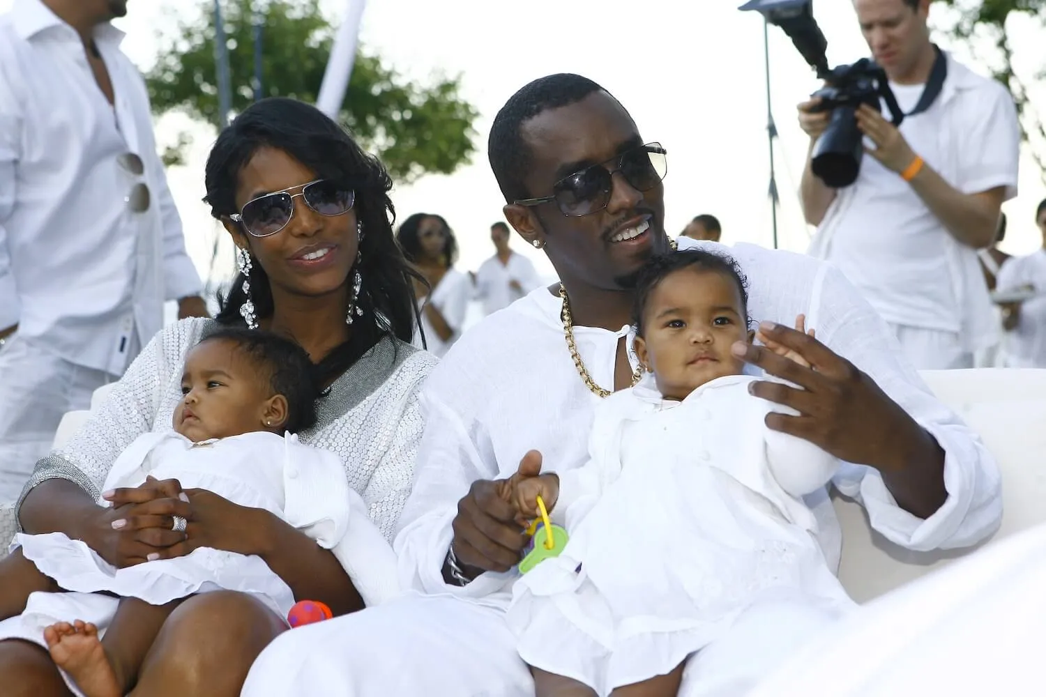 Kim Porter and Sean 'Diddy' Combs holding their twin daughters and wearing all white at a White Party