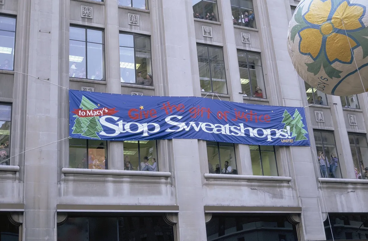 A banner protesting sweatshops on the side of a building during the 1996 Macy's Thanksgiving Day Parade