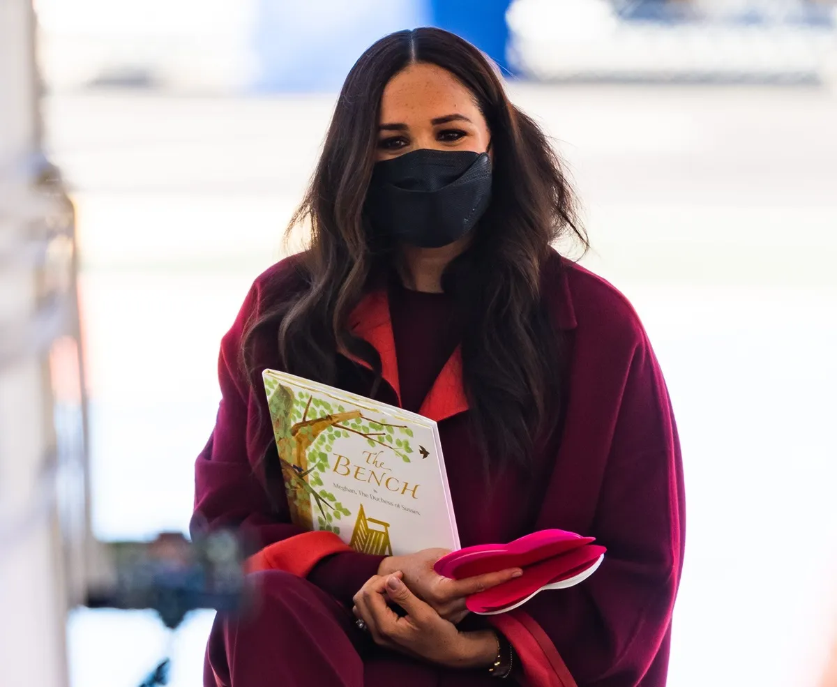 Meghan Markle holding her children's book while in the Harlem section of New York City