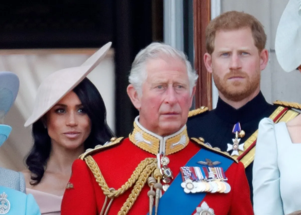 Meghan Markle, then-Prince Charles, and Prince Harry standing on the balcony of Buckingham Palace during Trooping the Colour 2018