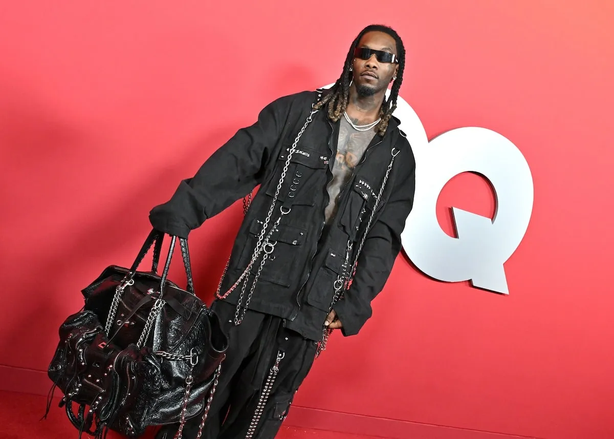 Wearing a black jacket and pants covered in chains, Offset poses for photos on the red carpet at the 2024 GQ Men Of The Year Party