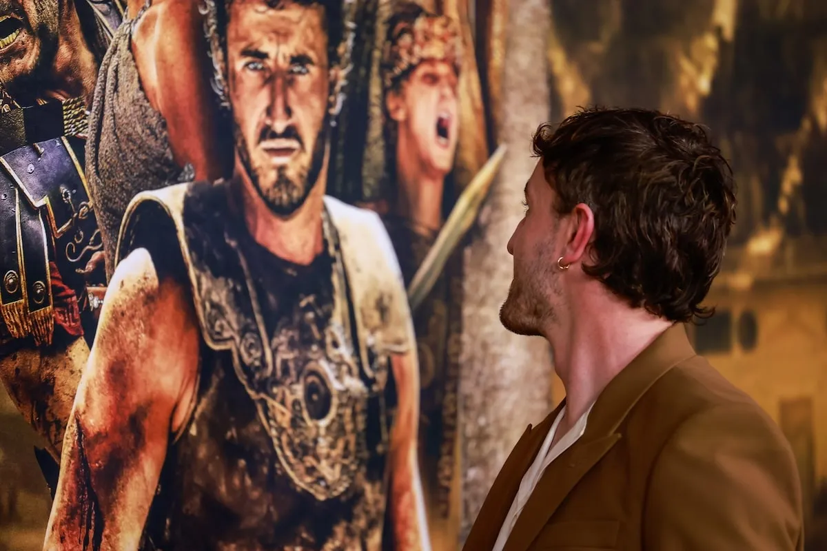 Actor Paul Mescal turns to look at himself on the movie poster for 'Gladiator II' at the Australian premiere