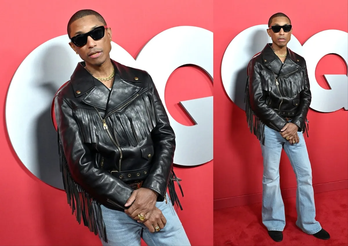 Wearing a leather jacket and flared jeans, Pharrell Williams poses for photos on the red carpet at the 2024 GQ Men Of The Year Party