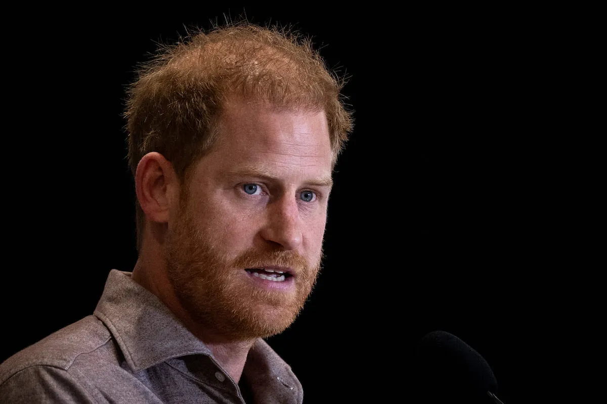 Prince Harry, whose road to a royal return may be easier when Sir Clive Alderton retires, looks on