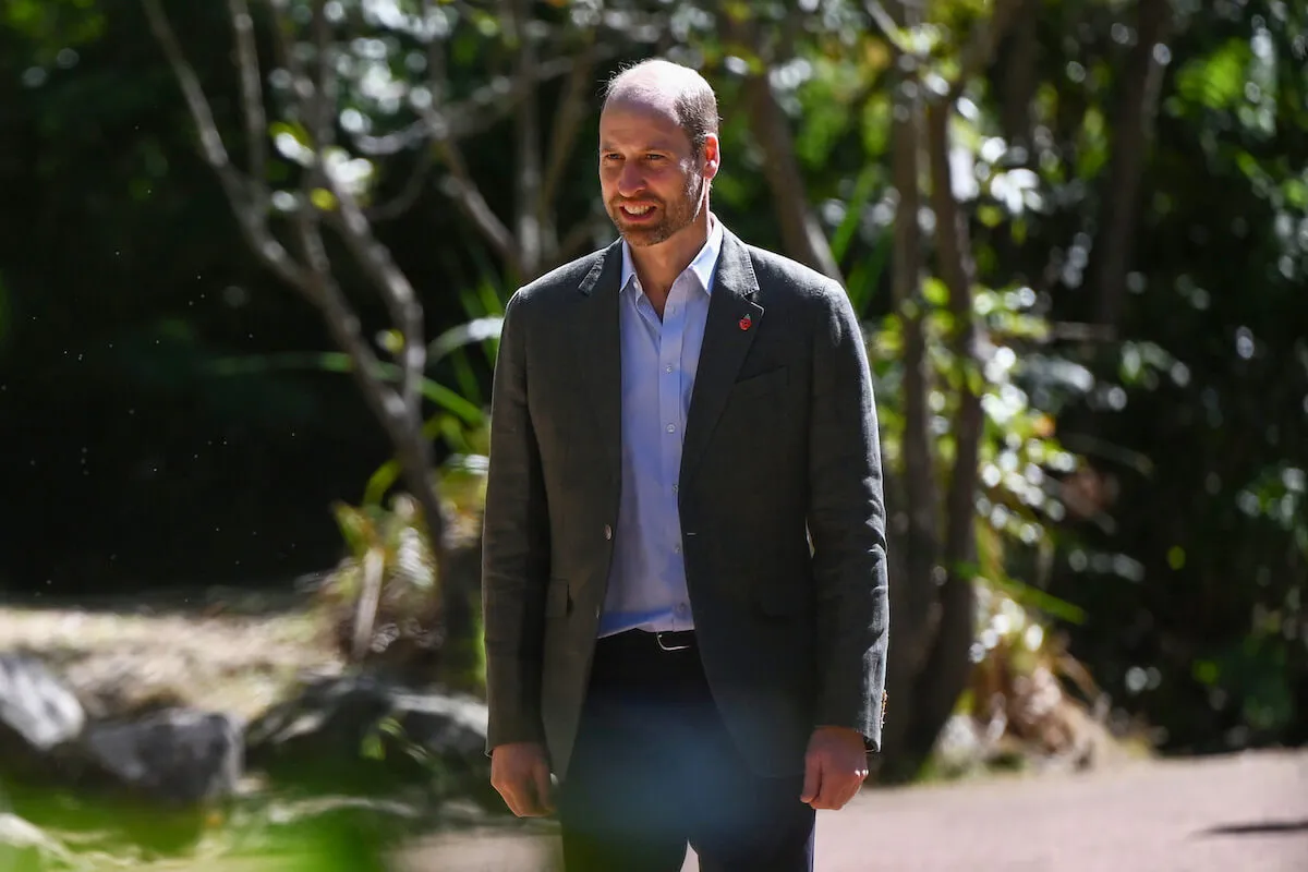 Prince William walks wearing a suit jacket.