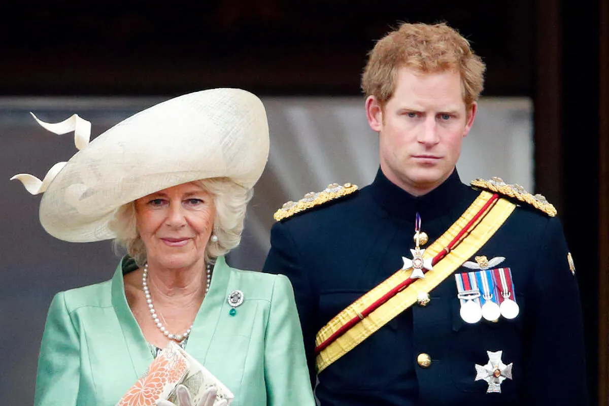 Queen Camilla and Prince Harry, who have switched places, stand next to each other