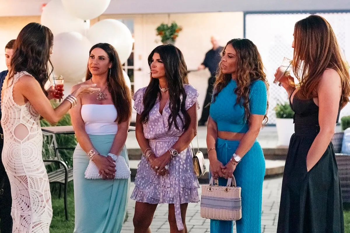 Cast members of 'The Real Housewives of New Jersey' standing in a row and holding their handbags