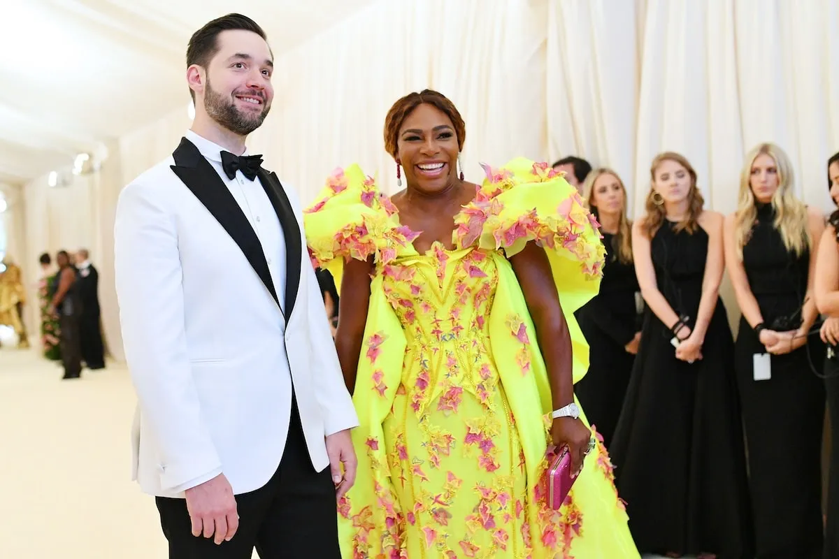 Wearing a bright yellow dress, Serena Williams laughs with her husband at the 2019 Met Gala