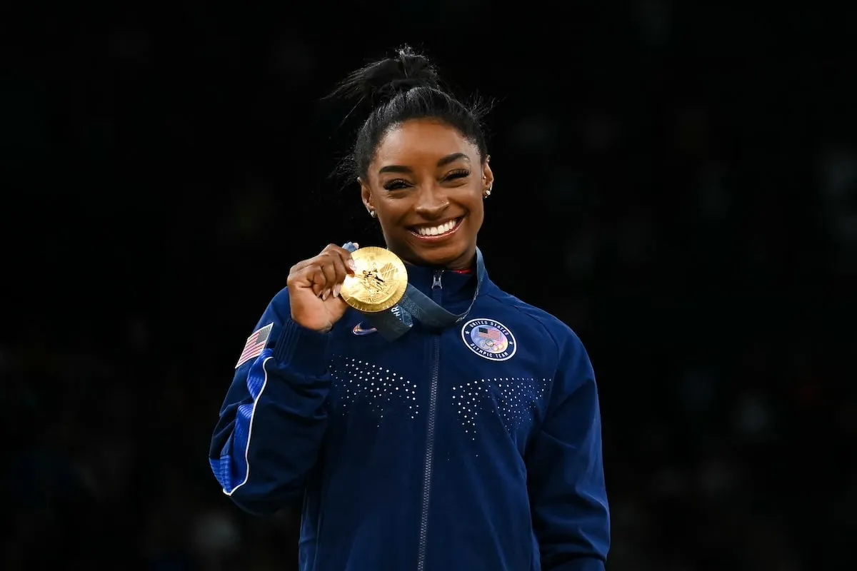 Olympic gymnast Simone Biles holds up her gold medal at the 2024 Summer Olympics