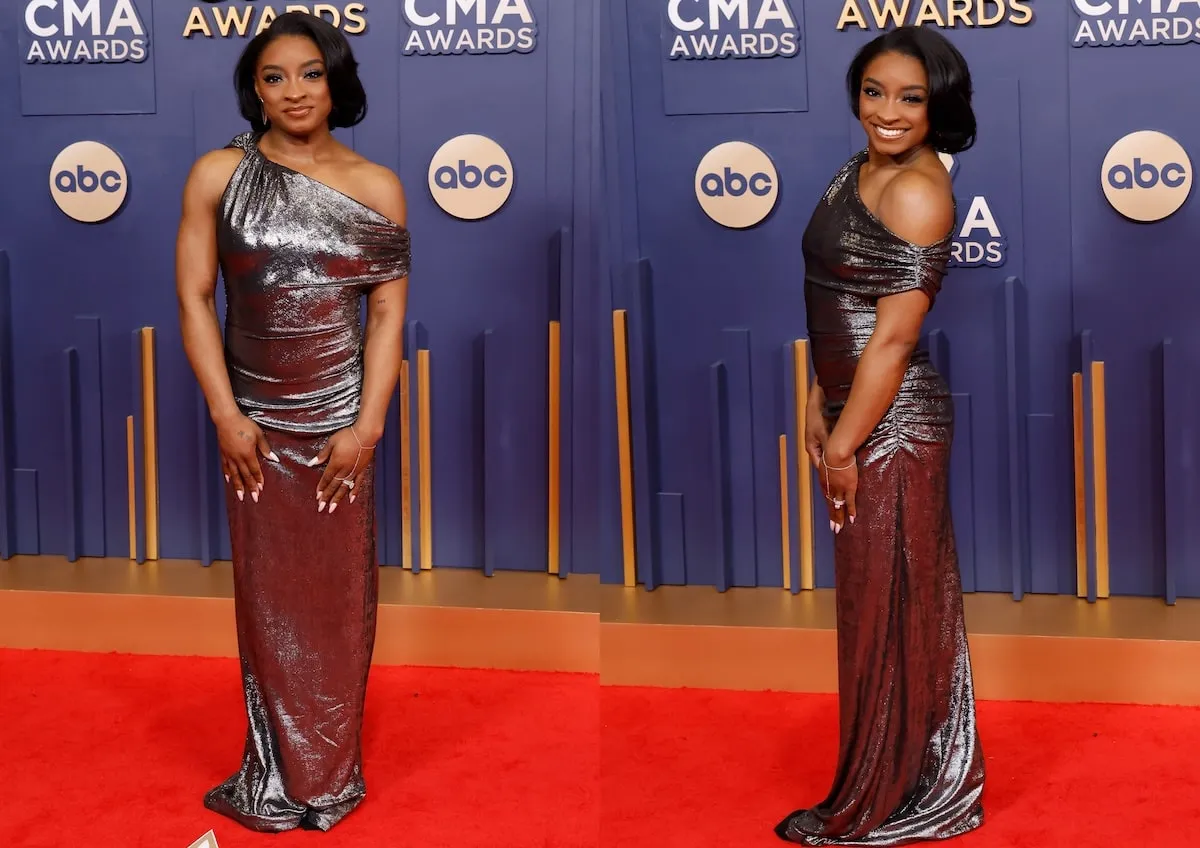 Wearing a silver gown, Simone Biles poses on the red carpet before the CMA Awards