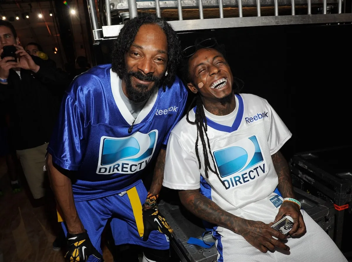 Rappers Snoop Dogg and Lil Wayne laugh together at a media event in 2013