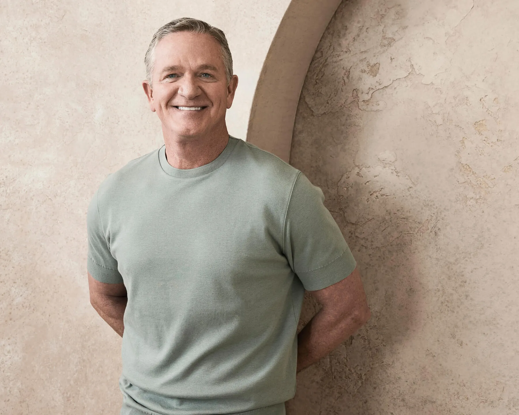 'The Golden Bachelorette' contestant Chock Chapple posing against a tan wall. He's smiling.