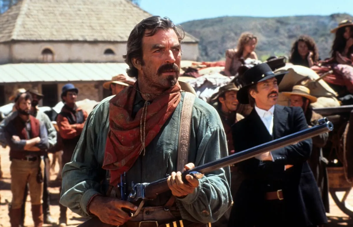 Tom Selleck dressed as a cowboy and holding a rifle in 'Quigley Down Under'