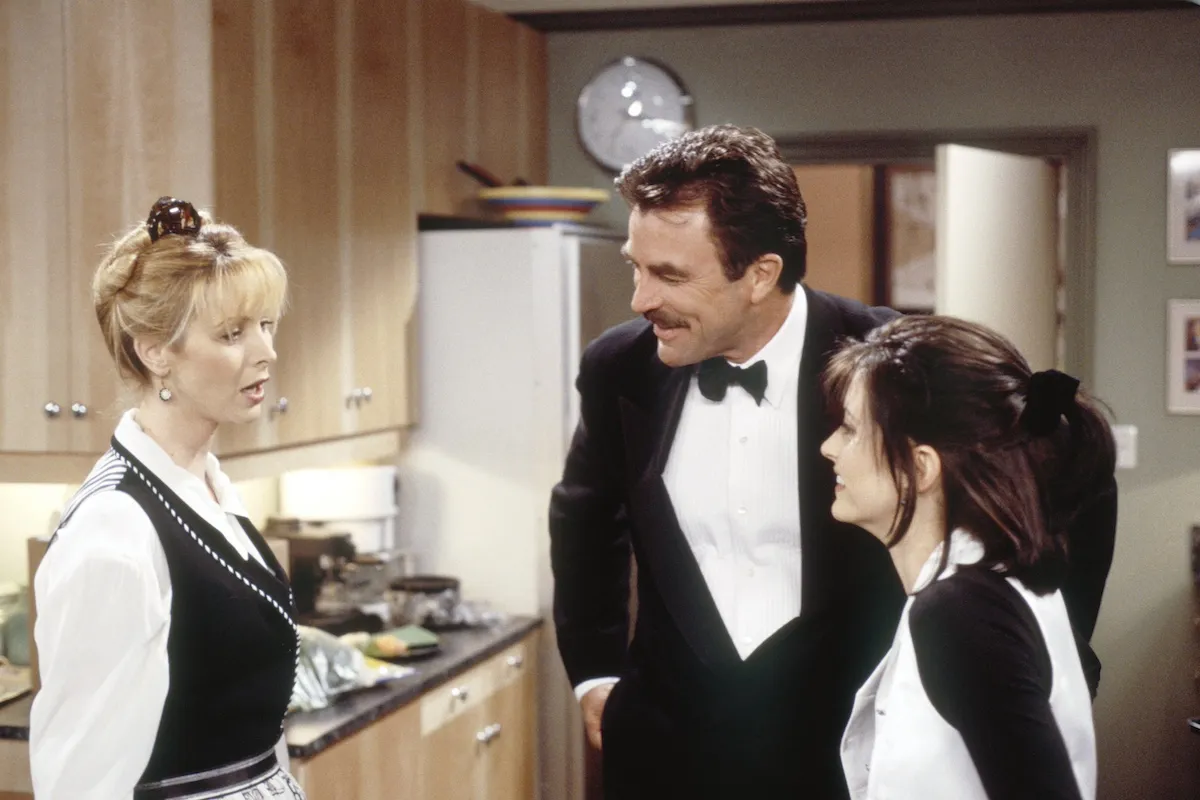 Tom Selleck, wearing a tux, standing between Lisa Kudrow and Courteney Cox in 'Friends'